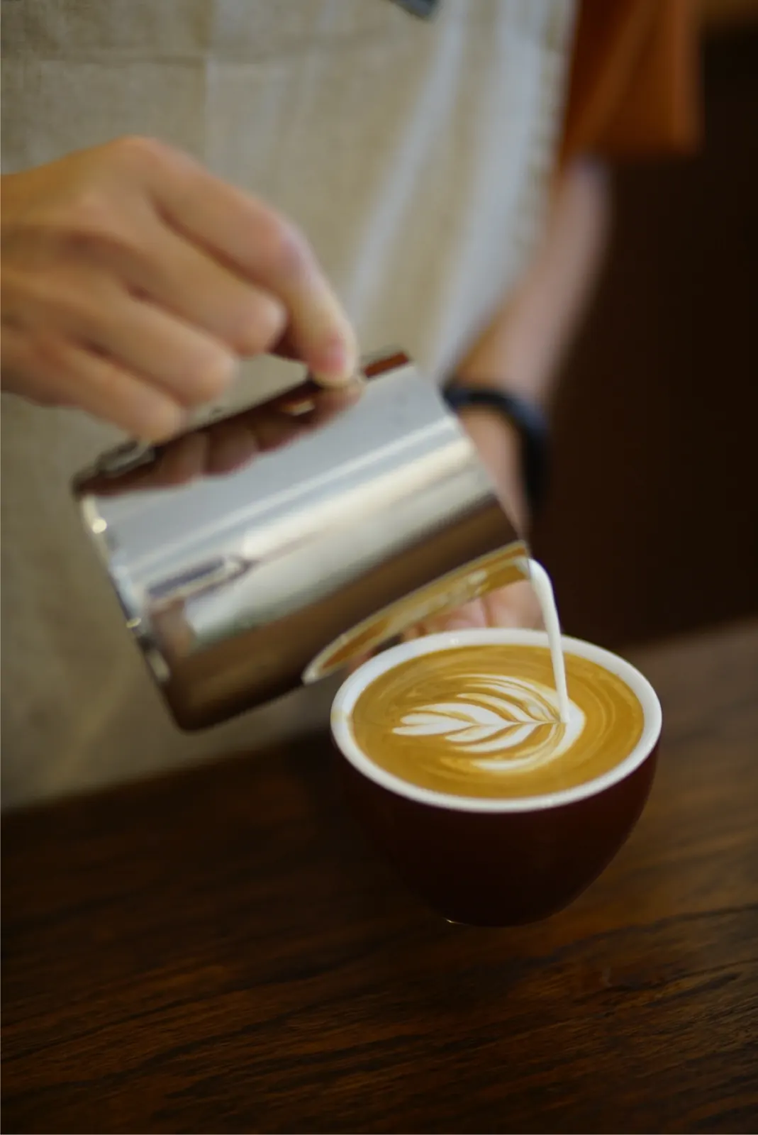 Latte art being poured by hand at baan125 hangout